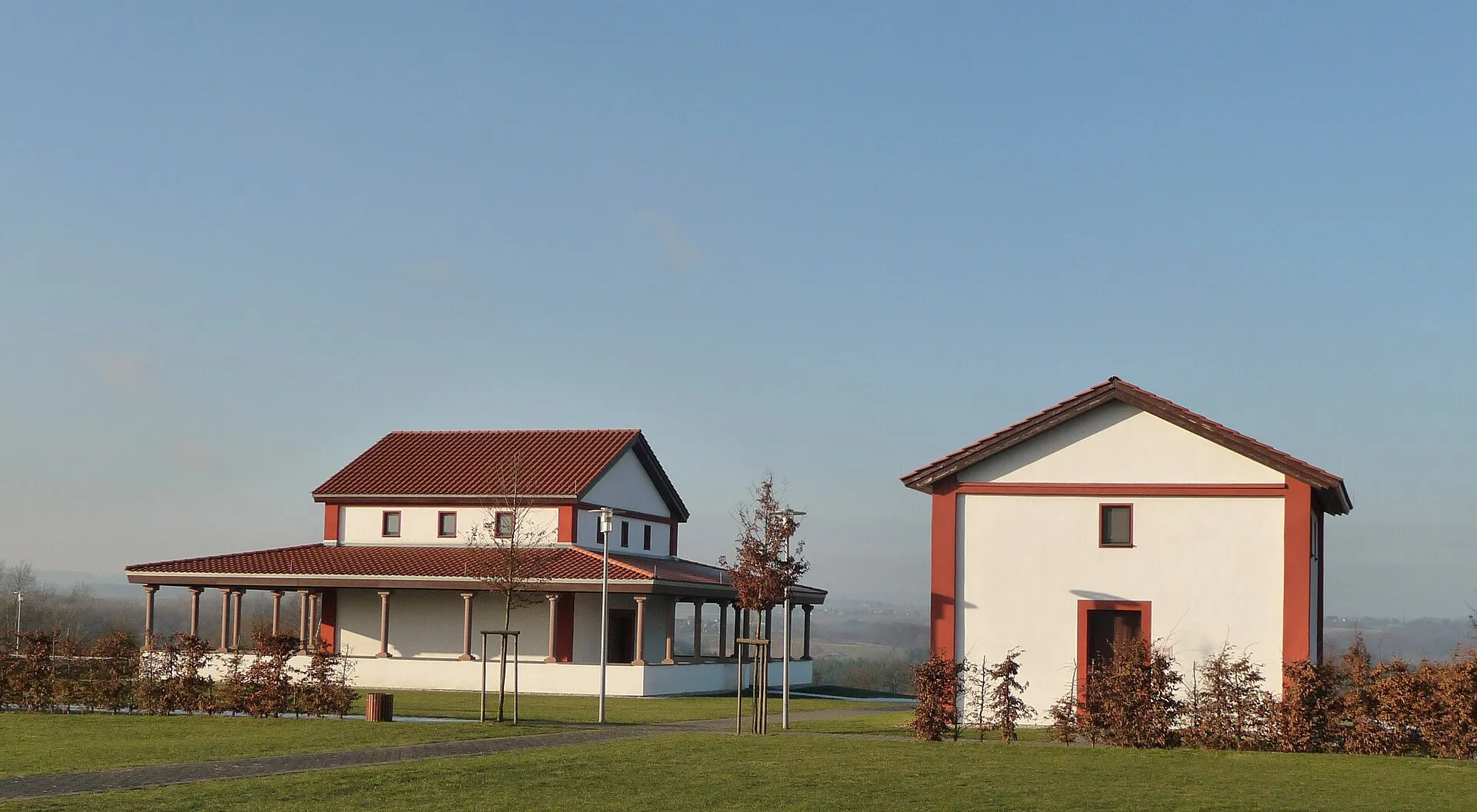 Rekonstruierter gallo-römischer Umgangstempel und ein weiß-roter Nebenbau auf dem Martberg über Pommern an der Mosel