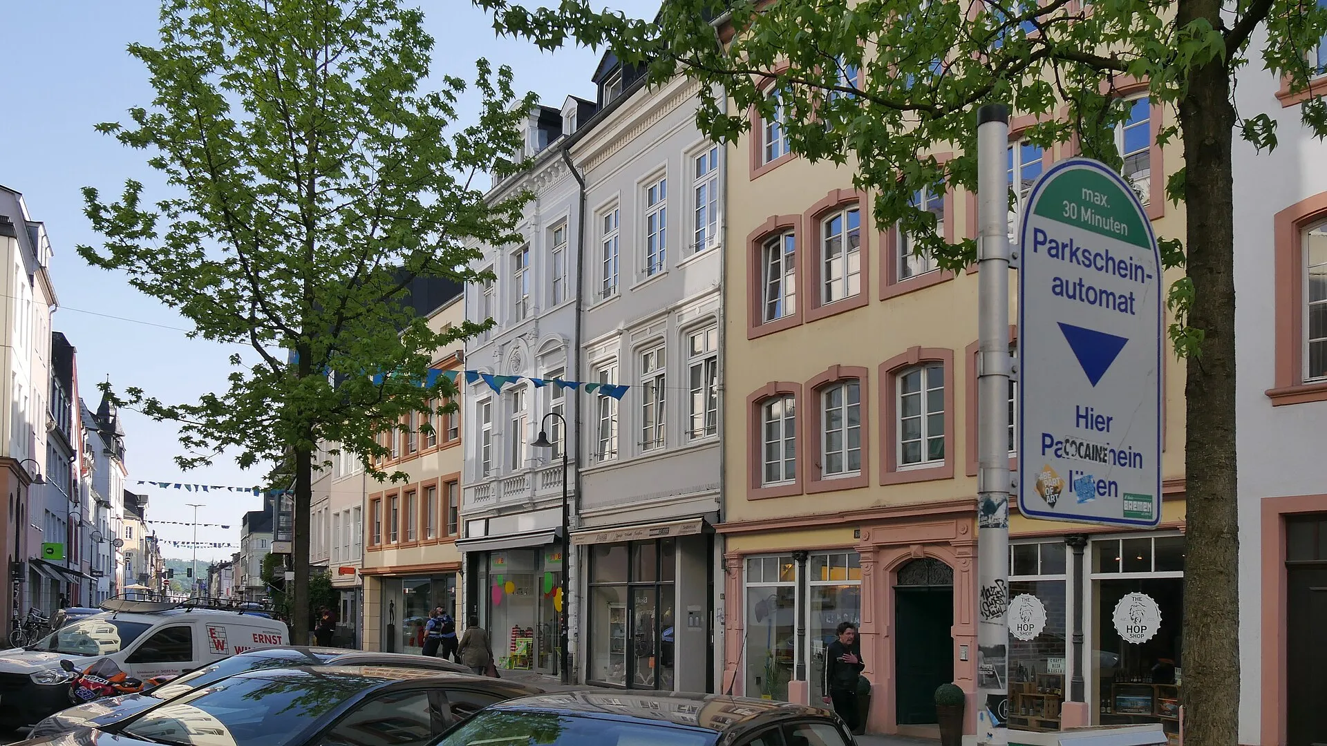 Die Neustraße in Trier mit den denkmalgeschützten Häuserfassaden der Nummern 42 bis 66 und Straßenbäumen